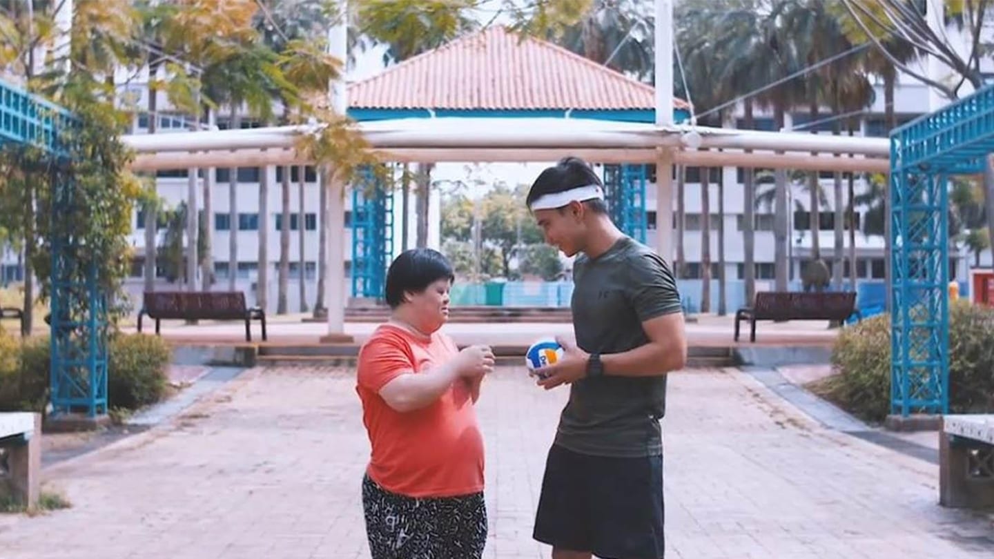 boy in white headband interacting with special needs girl in red shirt