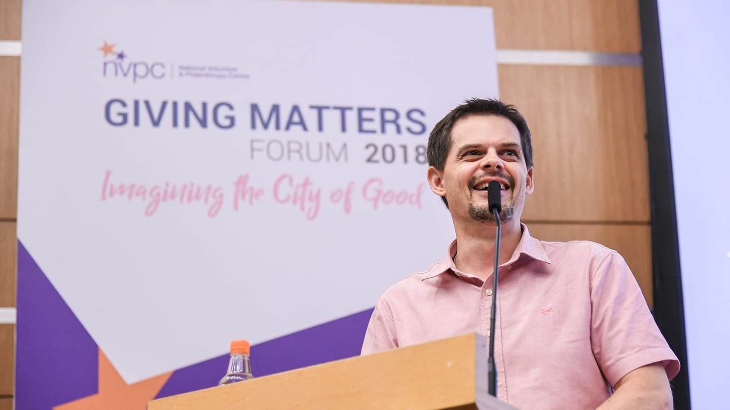 man in pink shirt giving a talk at giving matters forum 2018