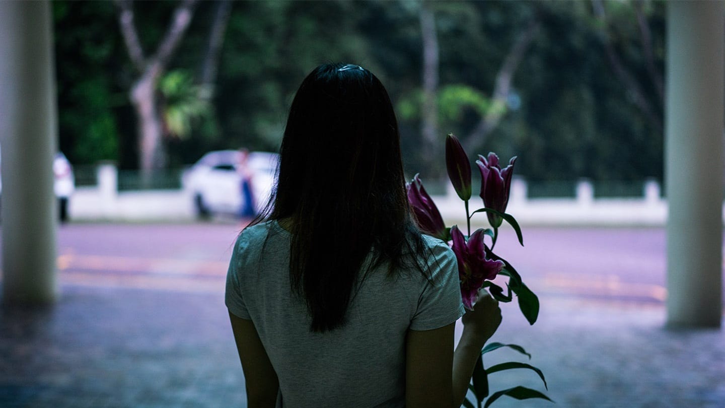 back view of woman holding a bunch of lilies