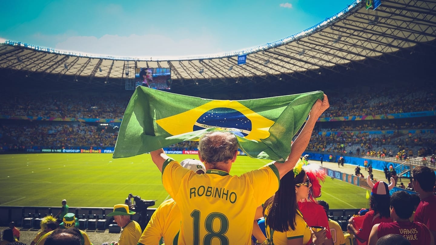 robin ho holding up brazilian flag at football game