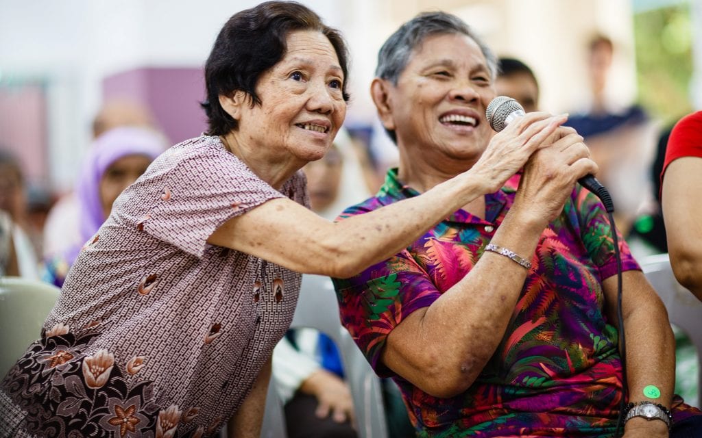 elderly man and woman enjoying a karaoke session