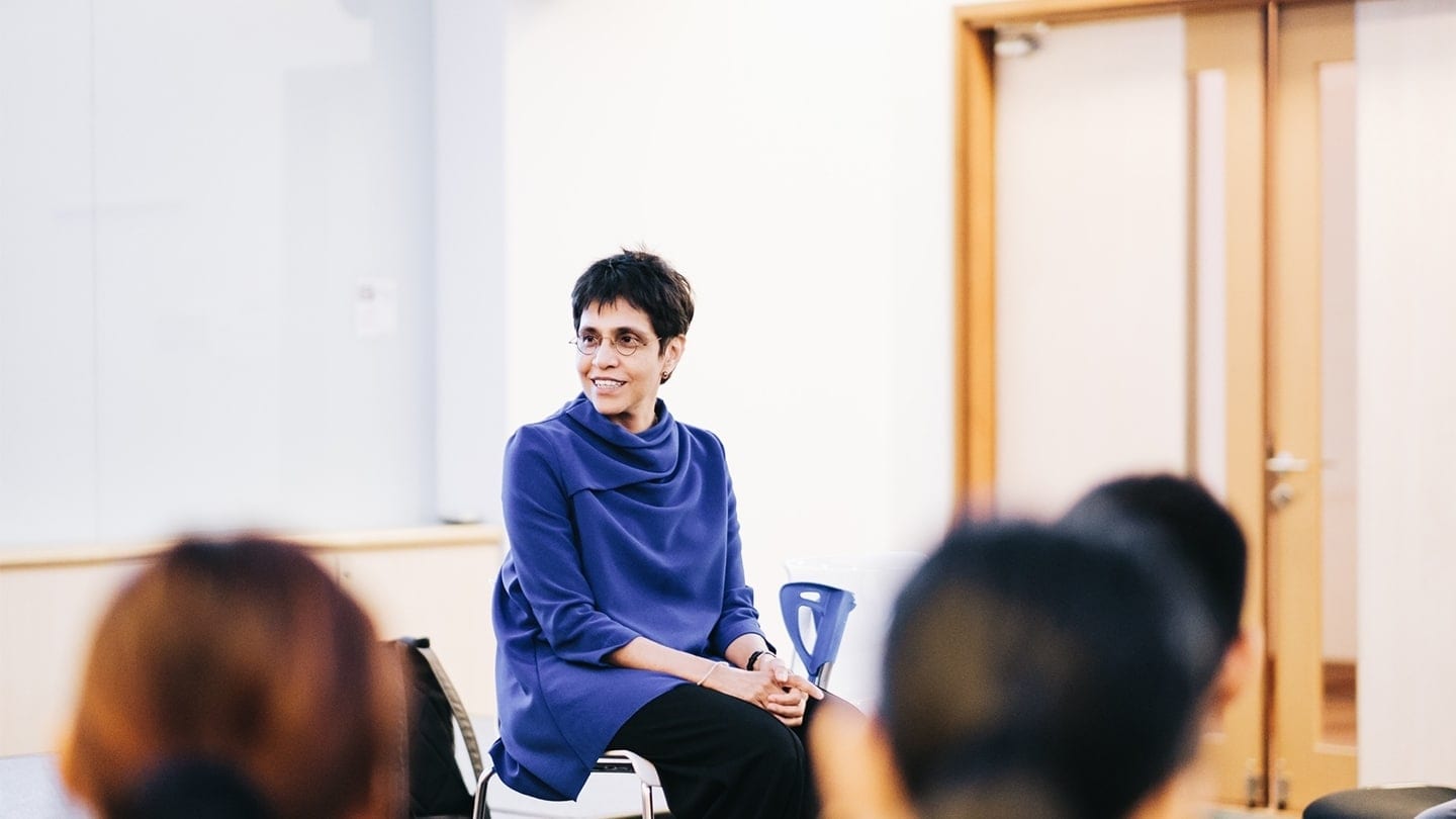 woman in blue shawl giving a talk