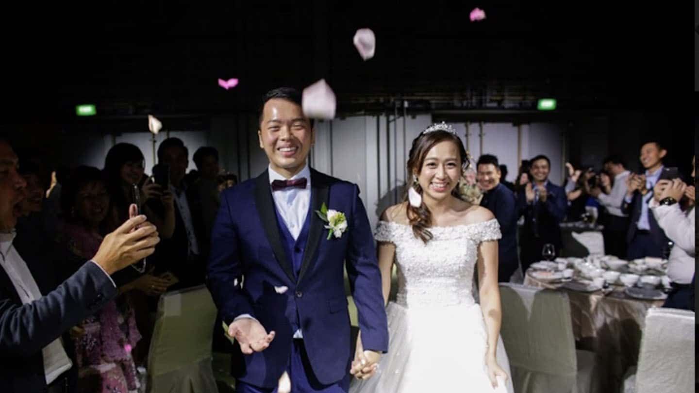 groom in blue suit and bride in white wedding dress walking down the aisle while smiling