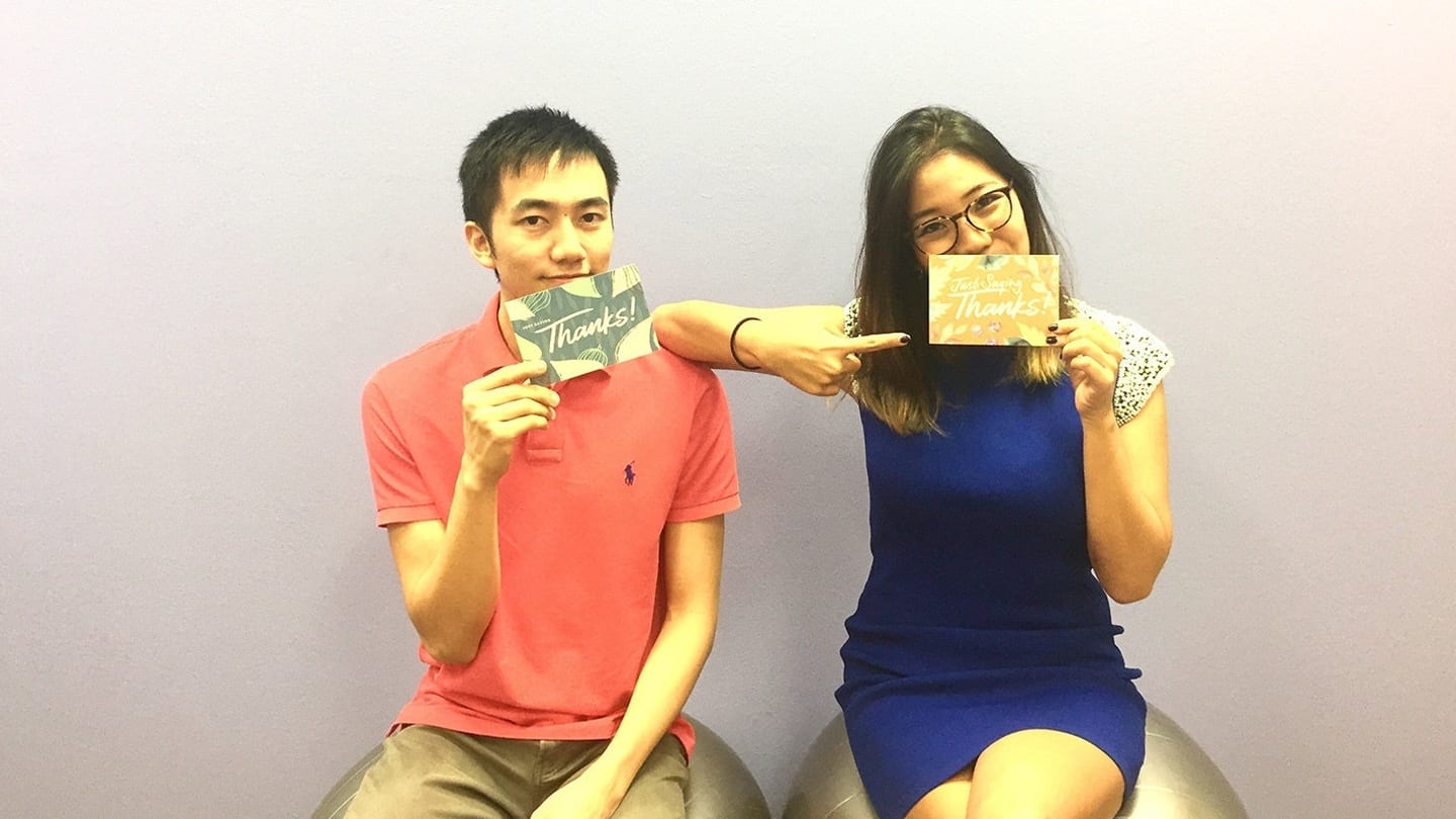 man and woman holding up thank you cards