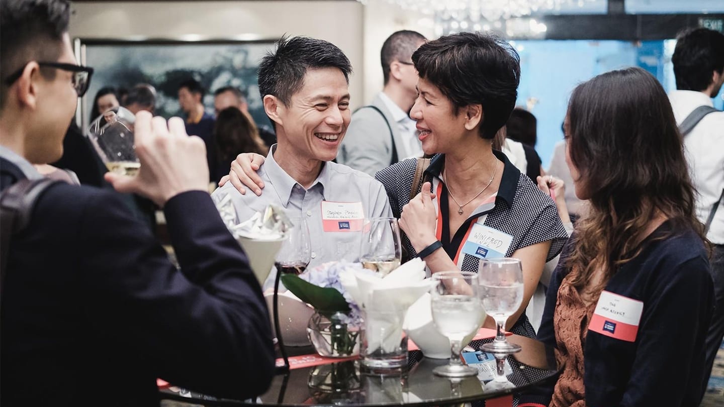 conference participants enjoying refreshments around table during reception