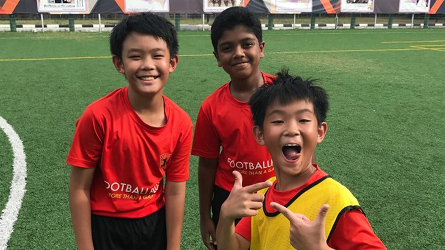 3 boys in red shirts that say football