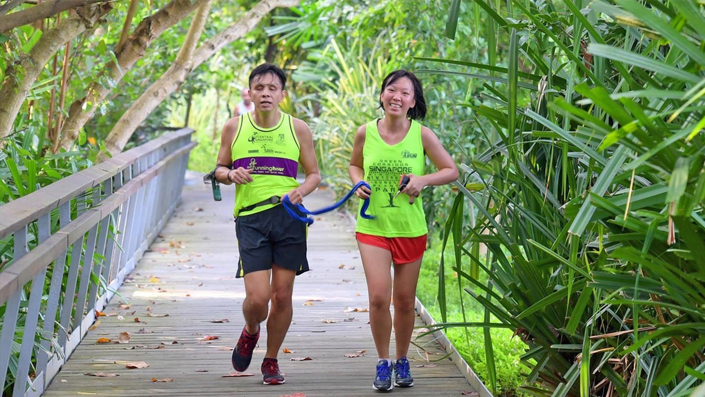 female volunteer leading visually impaired man during a race