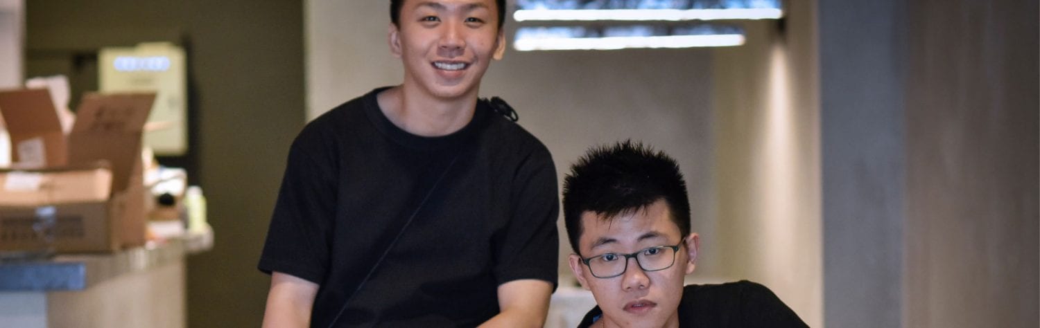 two men in plain black shirts posing for a photo