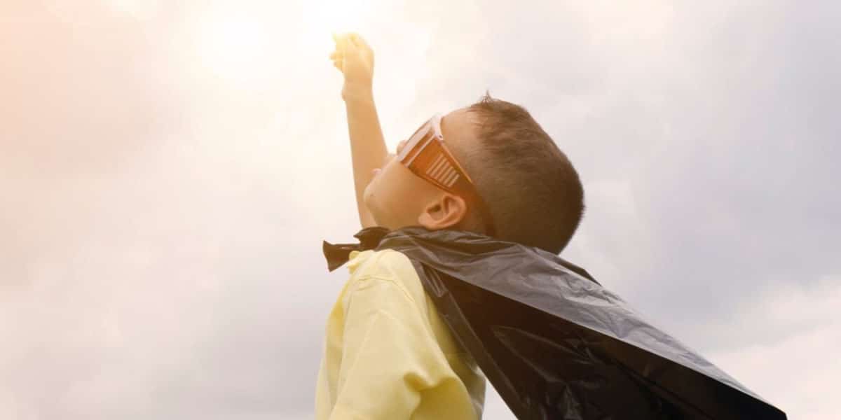 boy in yellow shirt black cape and really thick sunglasses