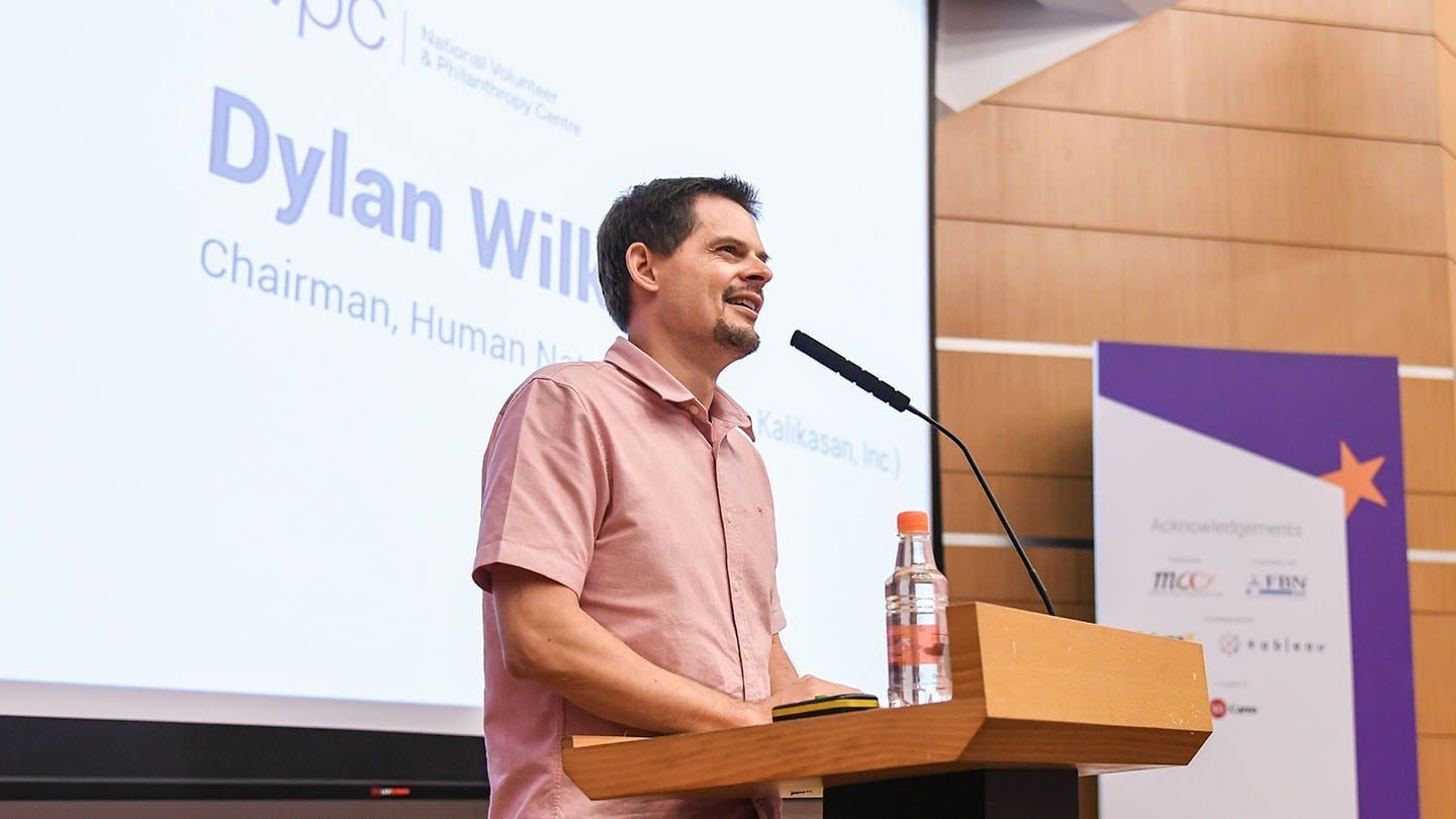 man in pink shirt giving a talk