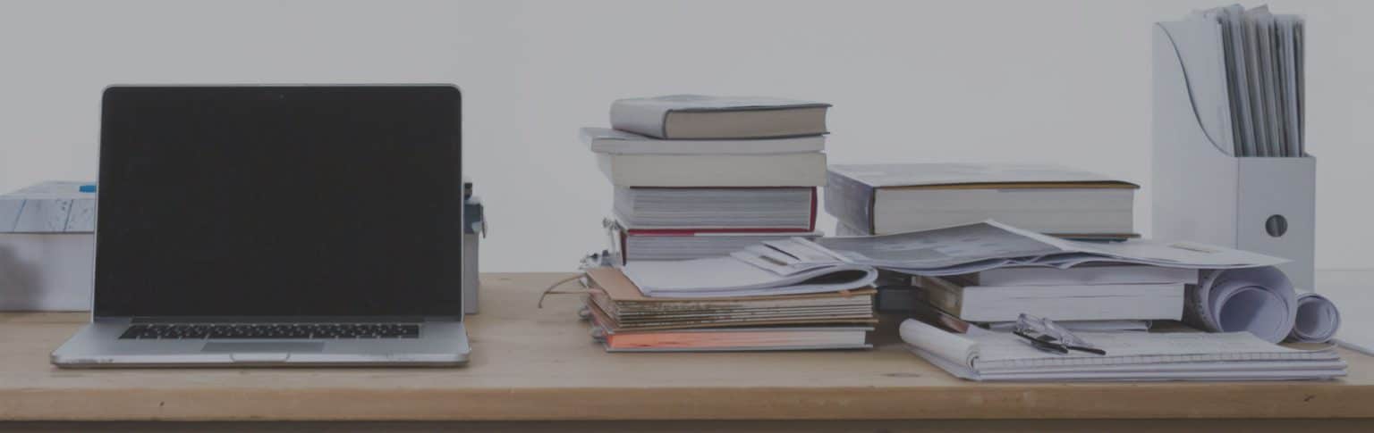 stack of books next to laptop