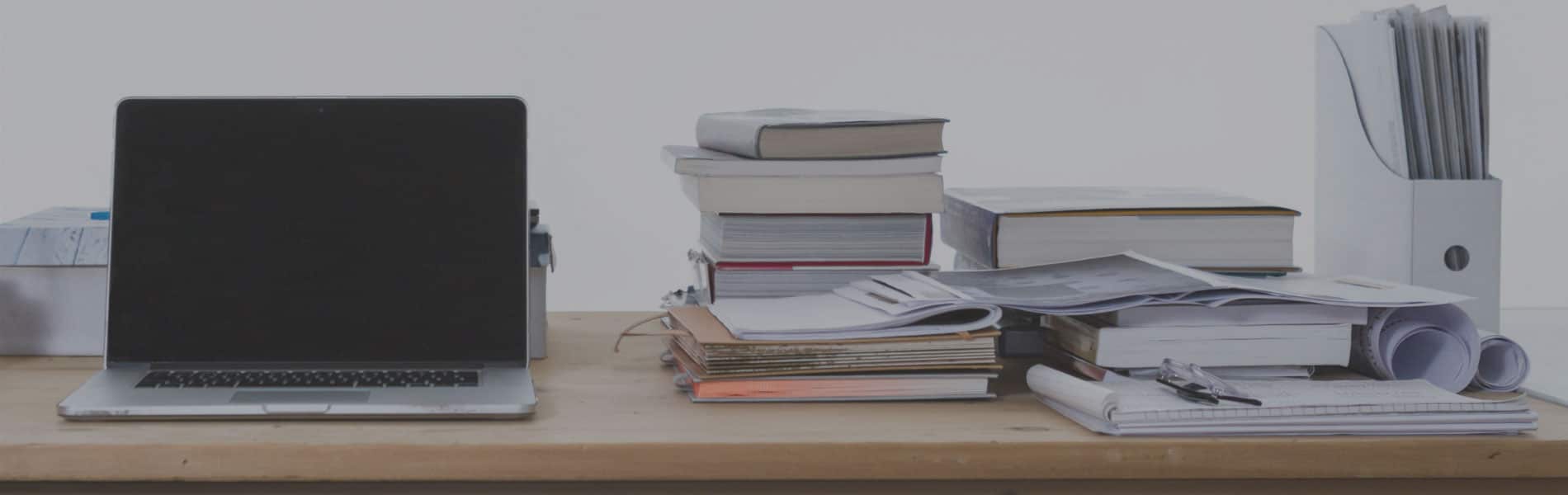 stack of books next to laptop