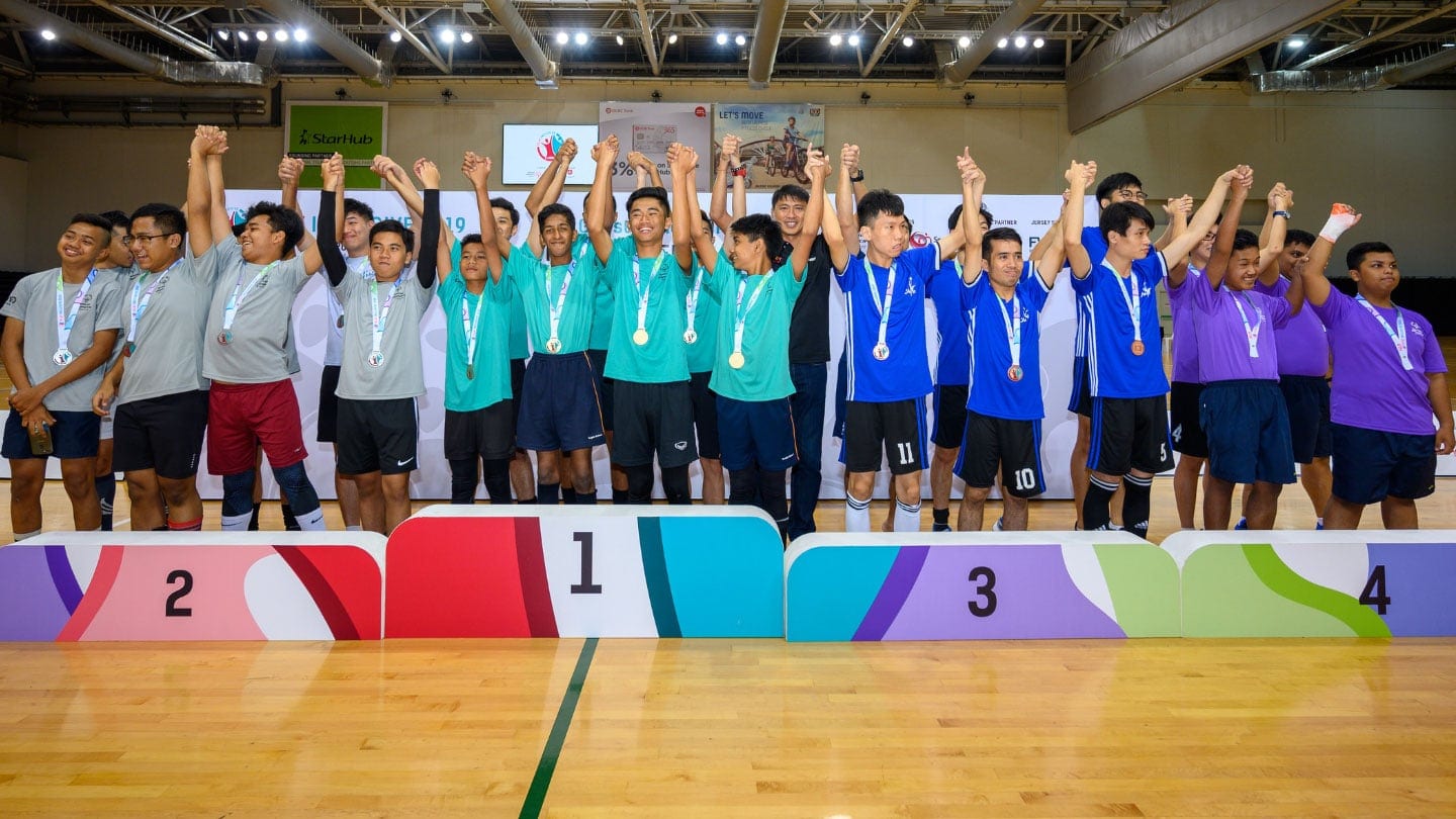 podium with teams in green grey blue and purple shirts