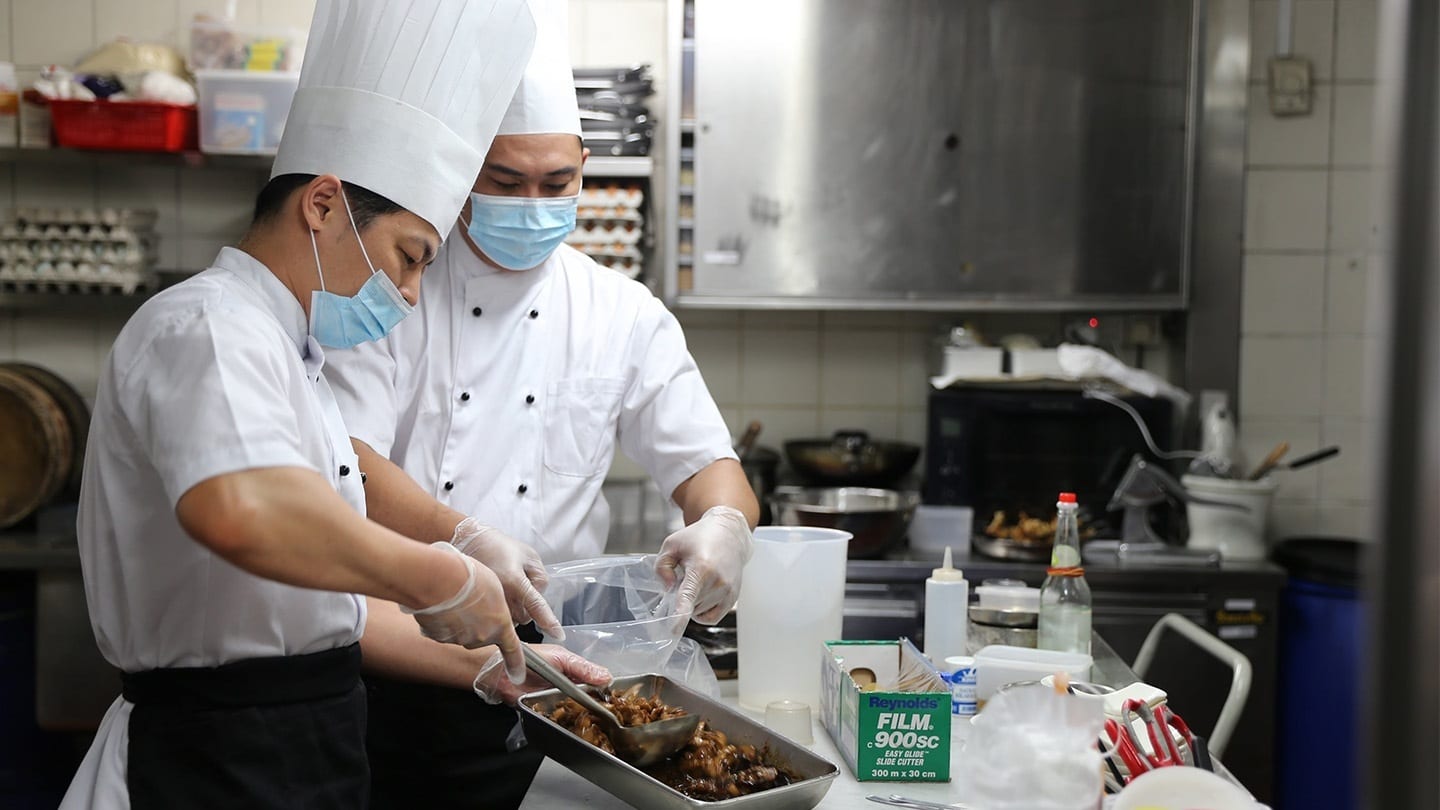 two cooks preparing food