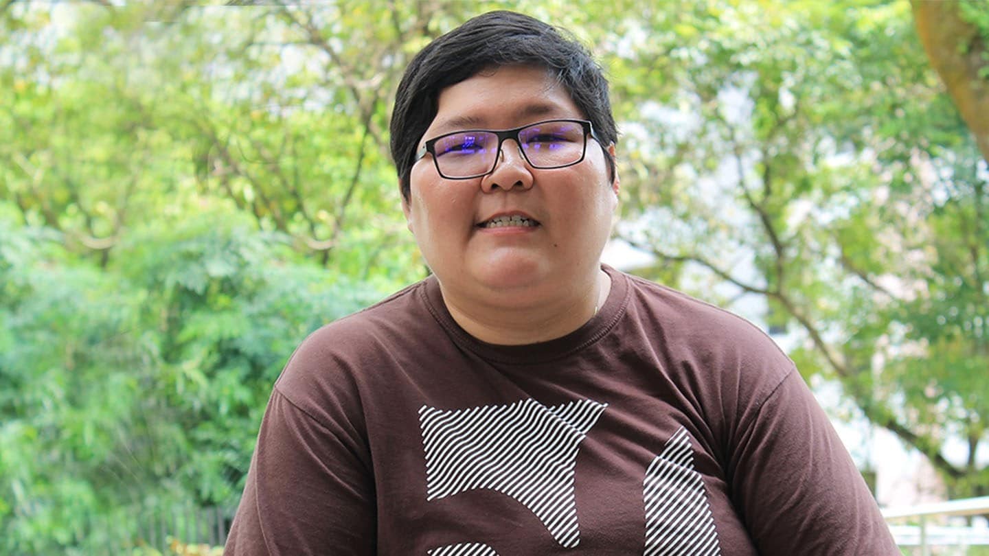 short-haired woman in brown shirt and black glasses posing for picture