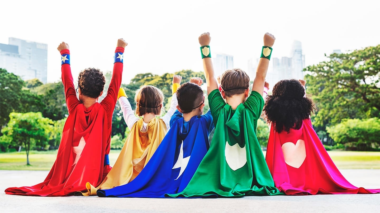 back view of five children in superhero capes