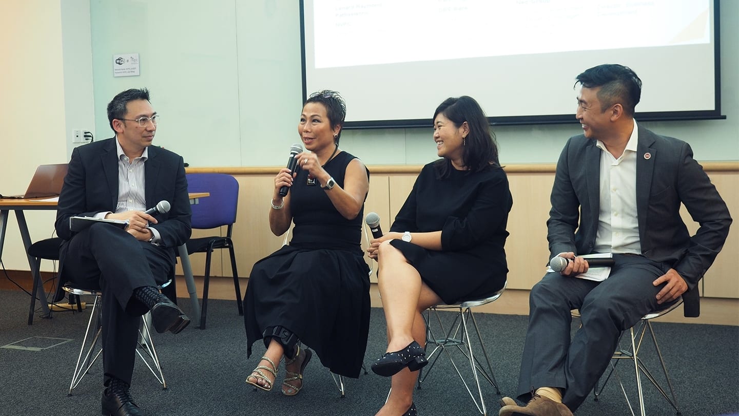 two women and two men all dressed in black giving a talk