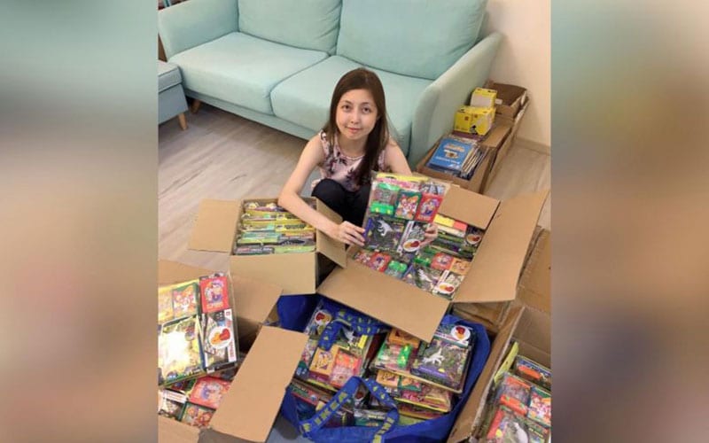 woman packing books into cardboard boxes