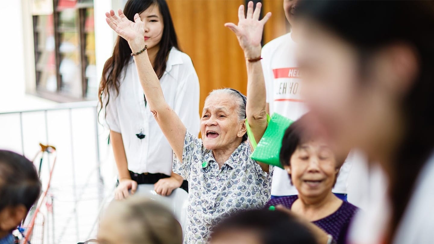 elderly lady participant raising both hands in the air