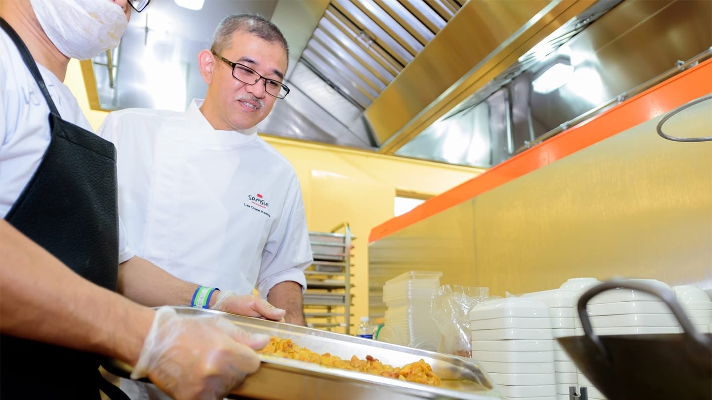 employee of samsui supplies and services watching man prepare food