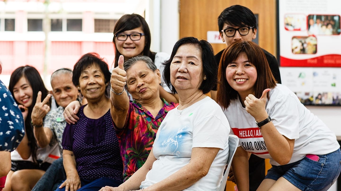 volunteers and elderly participants posing for photo