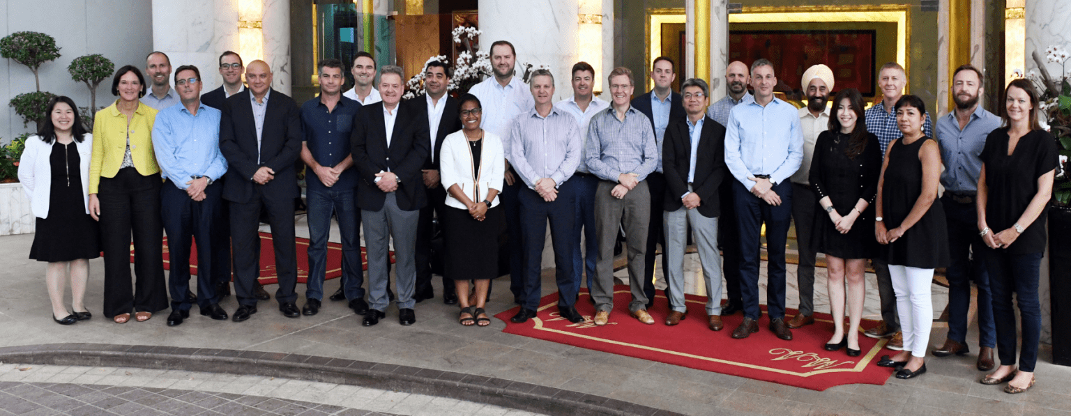 overseas delegates posing for a group shot outside hotel entrance