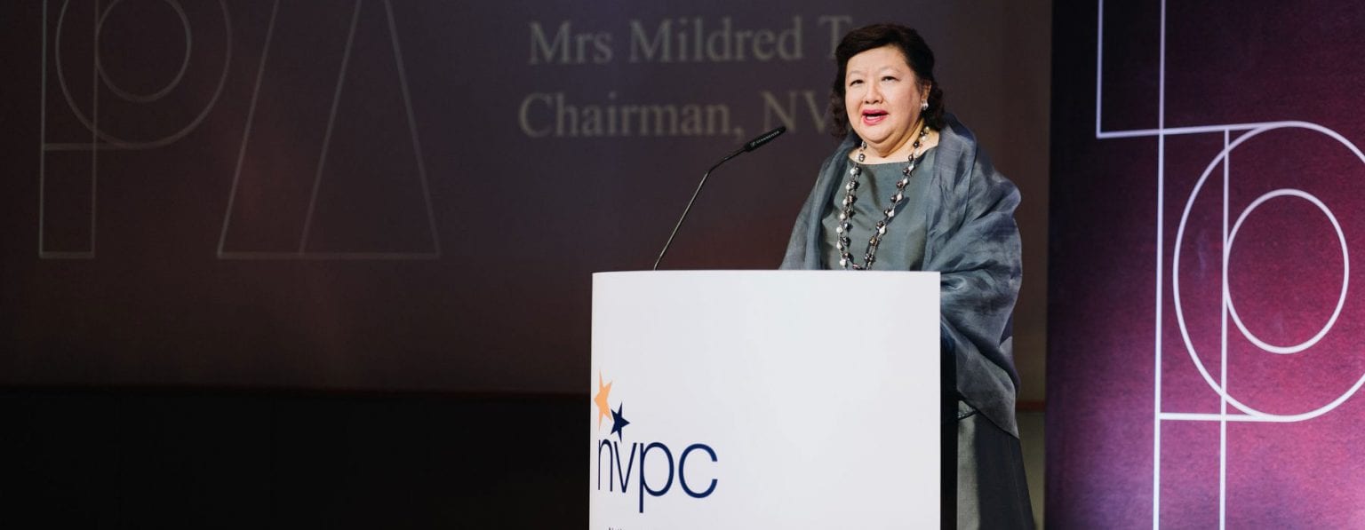 mrs mildred tan in a grey dress giving a talk