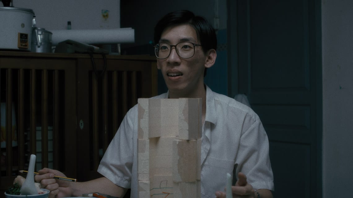 man in white shirt and black glasses with beige mockup structure in front of him