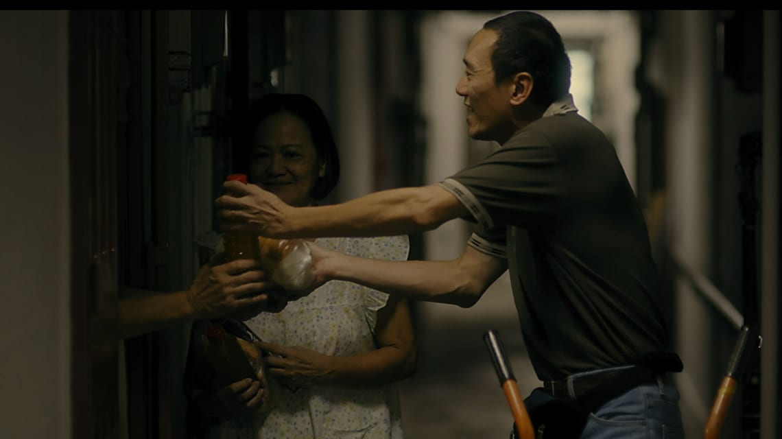 male and female volunteers handing drinks through door to tenant