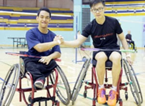 two male paralympians in wheelchairs holding each other's hand