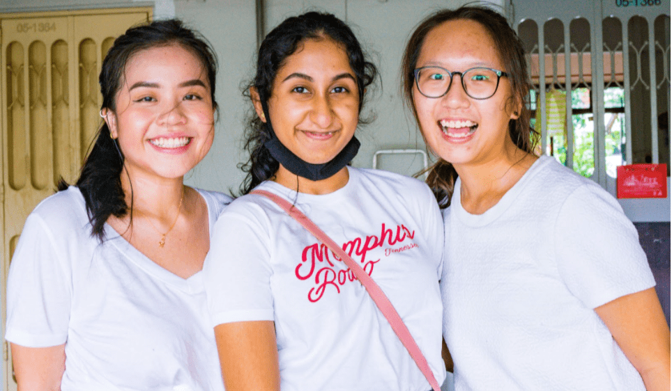 three girls in white shirts posing for a picture