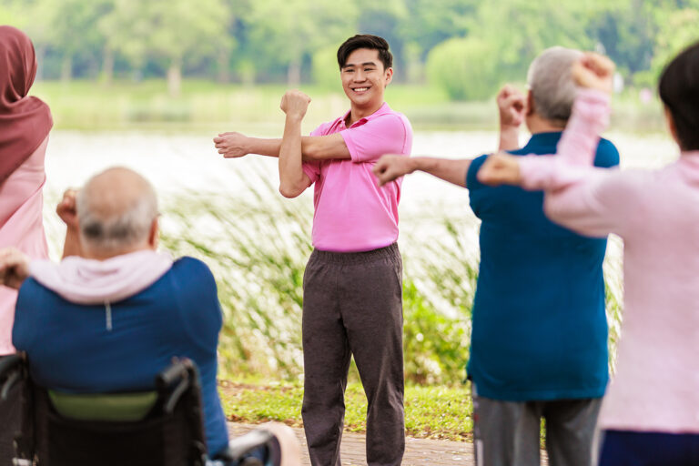 volunteer teaching elderly how to exercise