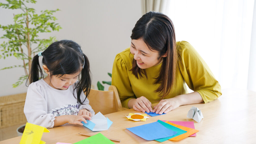 woman doing arts and crafts with child indoors
