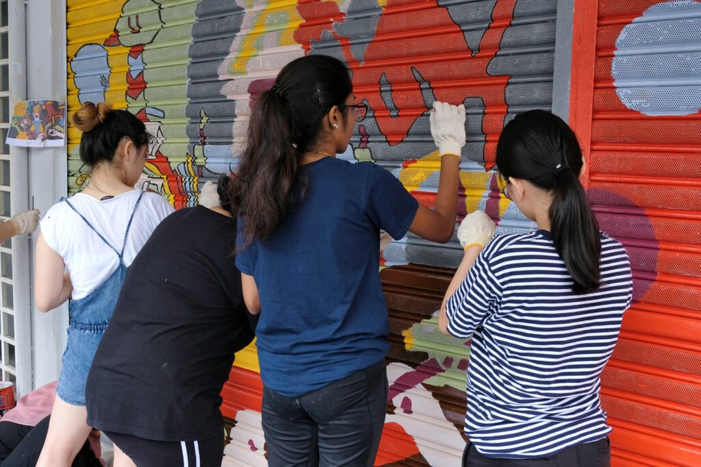 youth volunteers painting a wall