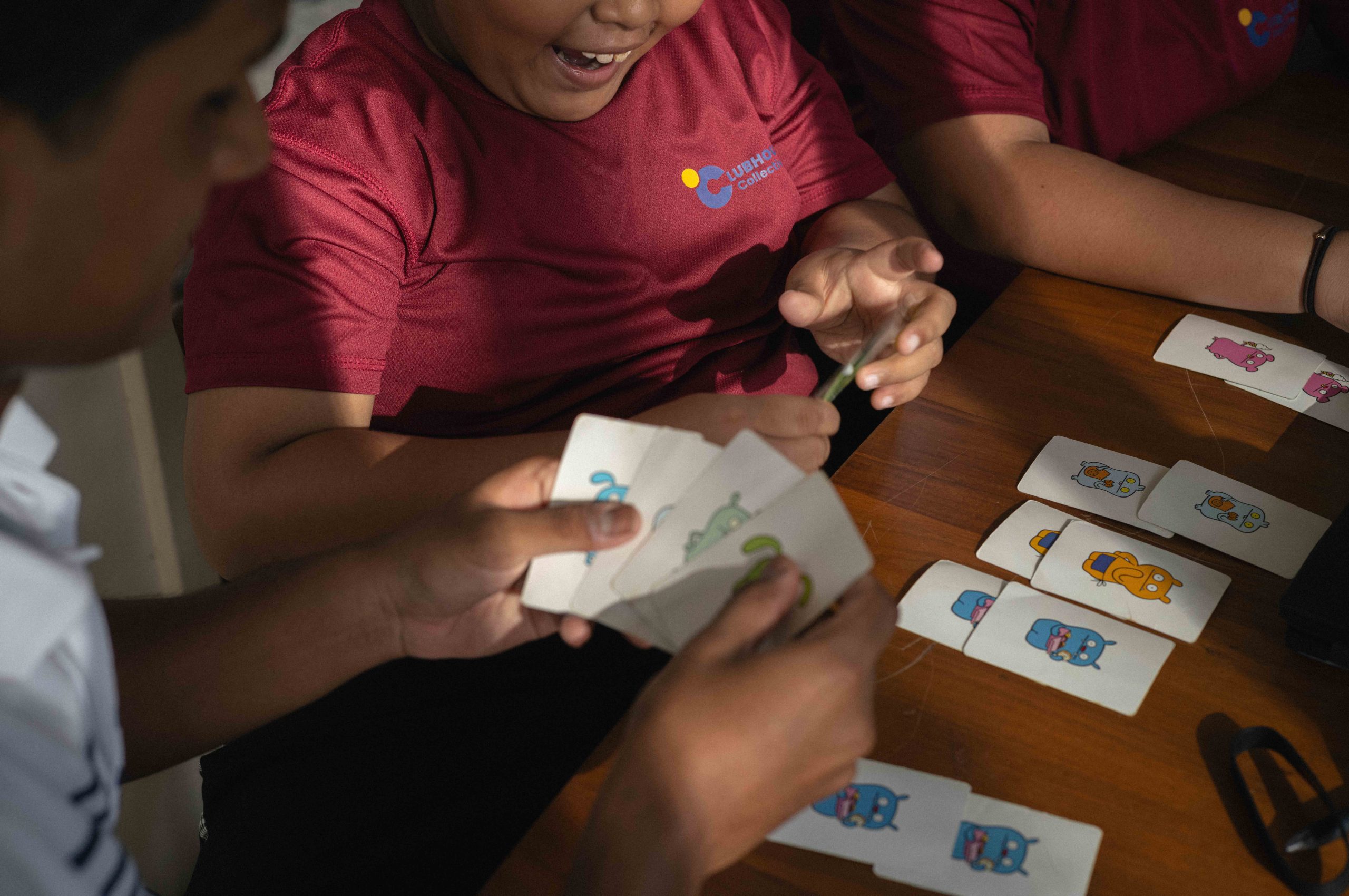 Children playing a card game at a charity