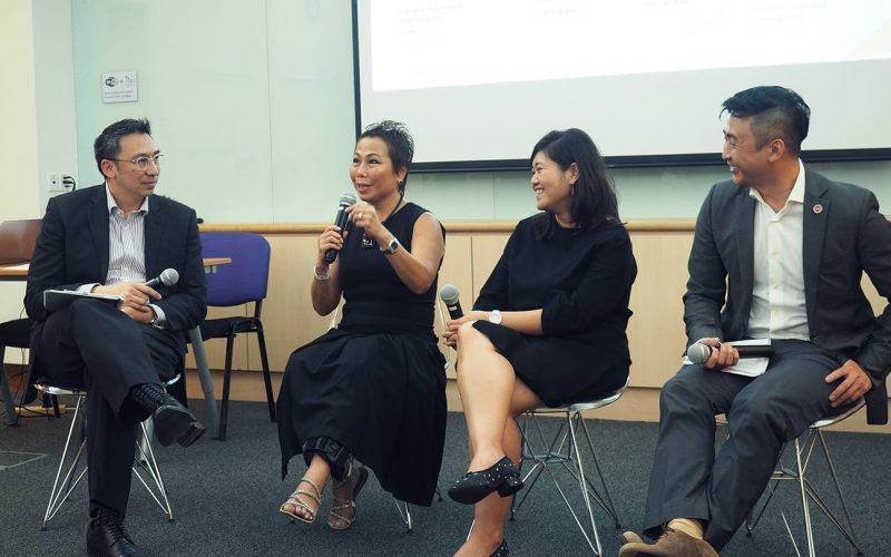 two women and two men all dressed in black giving a talk