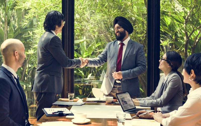 businesspeople shaking hands in a meeting room with greenery