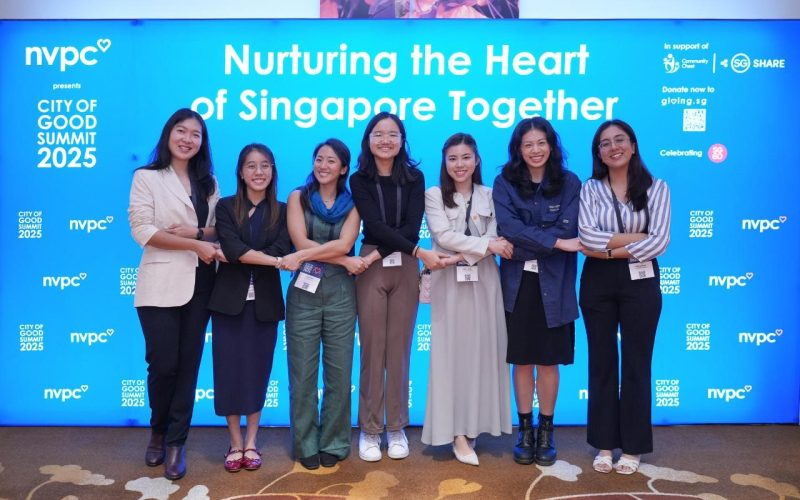 A group of guests at the City of Good Summit's photowall