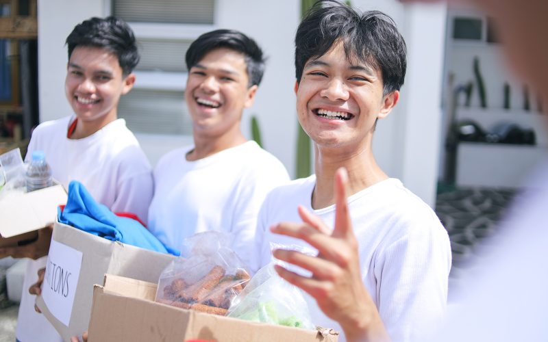 three male volunteers holding boxes
