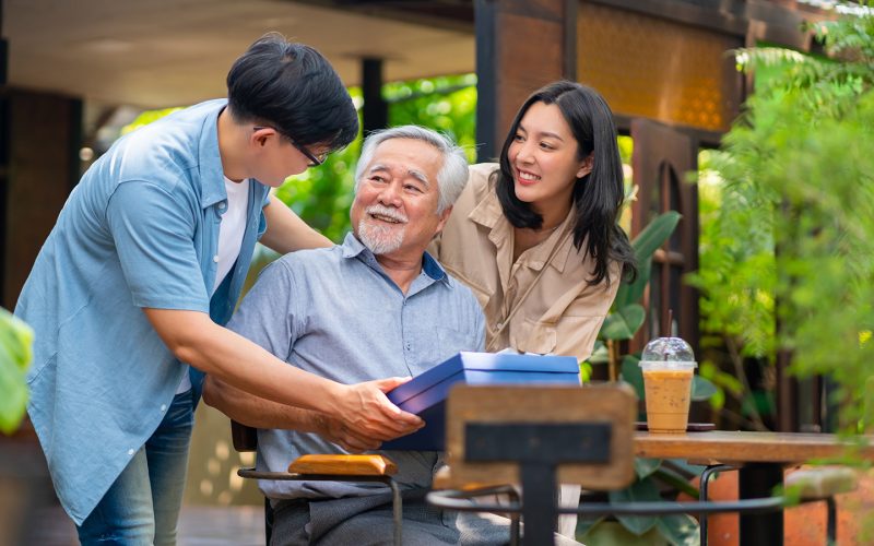 two young adults talking to an old man