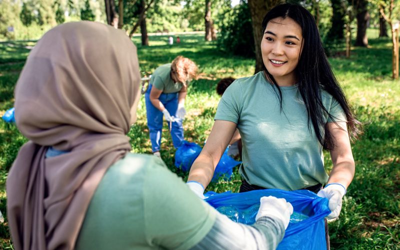 women cleaning up a park with rubbish bags